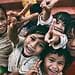 five children smiling while doing peace hand sign